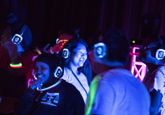 Students smiling while dancing at the silent disco